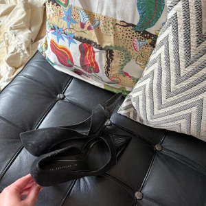 Svarta pumps med spetsig tå från Zara Trafaluc - Säljer ett par klassiska svarta pumps från Zara Trafaluc med spetsig tå och hög klack. Skorna har en elegant design i mocka och lack, perfekta för att lyfta vilken outfit som helst.