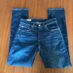 Mörkblå Levis 511 - Säljer ett par riktigt snygga  mörkblå Levis 511. Jeansen är aldrig använda så skicket är 10/10. De är perfekta att matcha till nästan varje outfit. Storleken är  W28 L30.