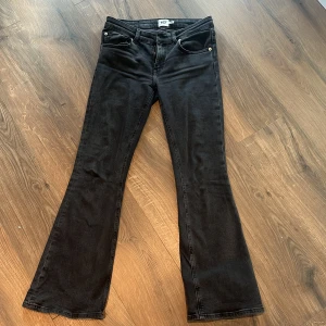 Svarta bootcut jeans från Lager 157 - Svarta jeans med bootcut-modell från Lager. Low waist och utsvängda ben. Jeansen har knapp och dragkedja framtill. Säljer då de är för korta
