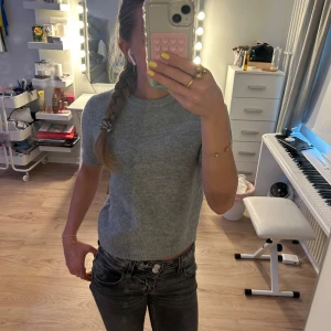 Grå stickad tröja från Zara🩶 - Säljer en enkel och stilren grå stickad tröja från Zara😇 Tröjan har korta ärmar, rund halsringning och är gjord i ett mjukt material som känns skönt mot huden och är mycket sparsamt använd🤍