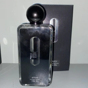 Afnan 9PM Eau de Parfum 100ml - Afnan 9PM(ca 90 ml kvar)  en stilren parfym i svart glasflaska med silverdetaljer och rund svart kork. Flaskan har en modern, maskulin design. Perfekt för dig som gillar eleganta och djärva dofter.