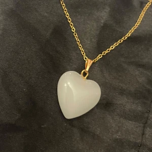 Vitt hjärta halsband glashjärta  - Sött halsband med en berlock av ett vitt glashjärta. Kedjan är i guldimitation och justerbar 40-45 cm. 