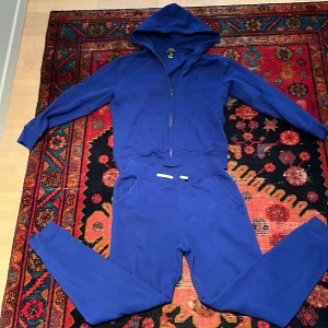 Blå dress från Polo Ralph Lauren - Tja! Säljer denna blåa dressen från Polo Ralph Lauren. Bara använd ett fåtal gånger och har nu vuxit ur mig. Storlek 14-16 år, så ungefär xs. Kontakta om du vill ha bara tröjan/byxorna så löser vi ett pris till det.