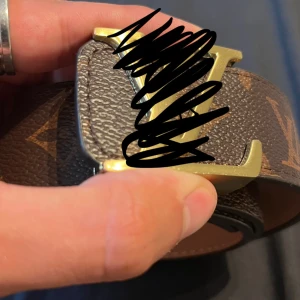 Brunt Bälte med Guldspänne - Hej! Säljer ett brunt bälte med klassiskt monogrammönster och guldigt spänne.  Perfekt accessoar för lite finare tillfällen.  Vill du veta något mer eller vill ha fler bilder så är det bara att skriva! Priset är såklart inte hugget i sten!