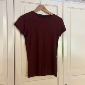 Mörkröd ribbad t-shirt - Mörkröd ribbad t-shirt.