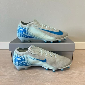 Nike fotbollsskor med blå detaljer - Säljer dessa Vapor 16 Elite i storlek 42,5. Skorna är anända sparsamt och i väldigt bra skick. Påse ingår och dom kan hämtas kring Göteborg/trollhättan. 