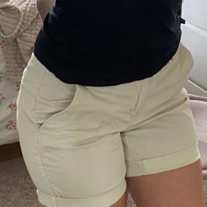 Beige shorts  -  beige shorts med klassisk passform och uppvikta benslut. Mjuk bomull 