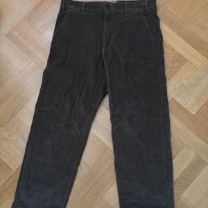 Mossgröna manchesterbyxor från Knowledge Cotton Apparel - Säljer ett par mossgröna manchesterbyxor från Knowledge Cotton Apparel i storlek 32. Klassisk rak passform med fickor fram och bak, perfekt för dig som gillar en tidlös stil. Snygga att matcha med både skjorta och t-shirt.