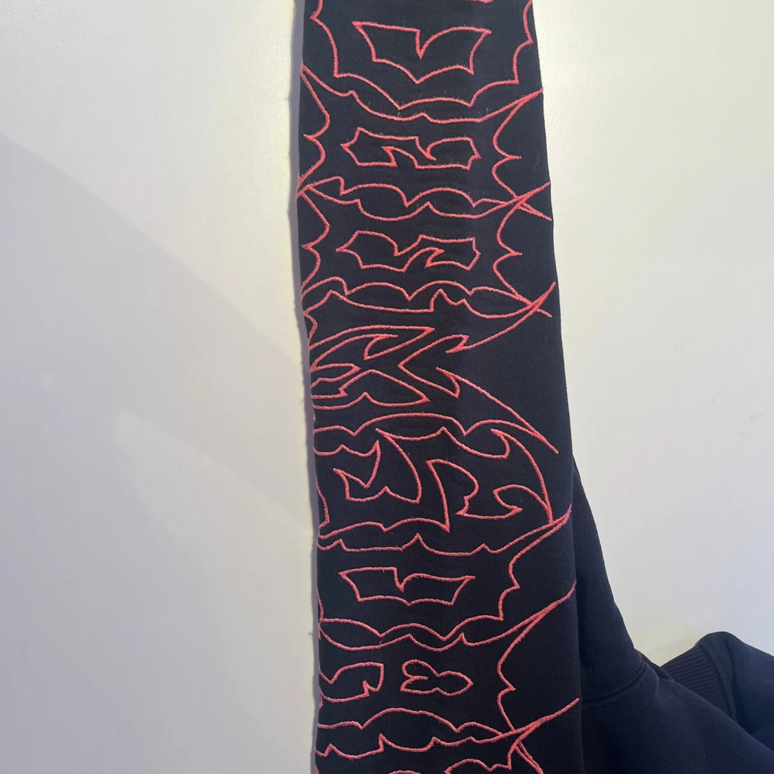 Svart hoodie med röd grafik på ärmar - 3