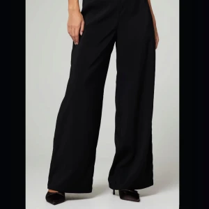 Svarta kostymbyxor  - Svarta kostymbyxor från bik bok. Modell:  ”Ava Petit”  stl.36. Jag är 163cm och de slutar precis ovanför marken på mig. ALDRIG ANVÄNDA! Nypris: 399kr