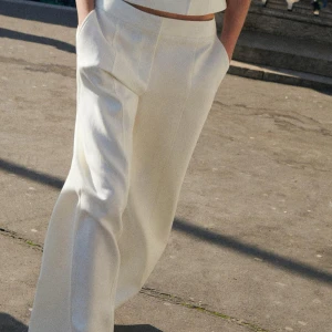 Vita kostymbyxor - Snygga vita kostymbyxor med hög midja och vida ben. Perfekta för en stilren look. Byxorna har en klassisk design med fickor och en elegant passform. Använda en gång.