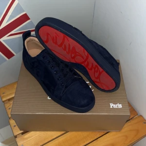 Mörkblåa Louboutin Louis 41/42 - Snygga mörkblåa sneakers i mocka med den ikoniska röda sulan från Christian Louboutin i storlek 41/42. Inga defekter eller liknade, dom har använt sparsamt och aldrig i blött väder eller liknade så mochan är i sitt original skick. Allt som kom vid inköp så som dustbags  osv finns kvar endast några små defekter på lådan skriv vid intresse. Priset är ej fast men behöver inte heller bli av med dom.