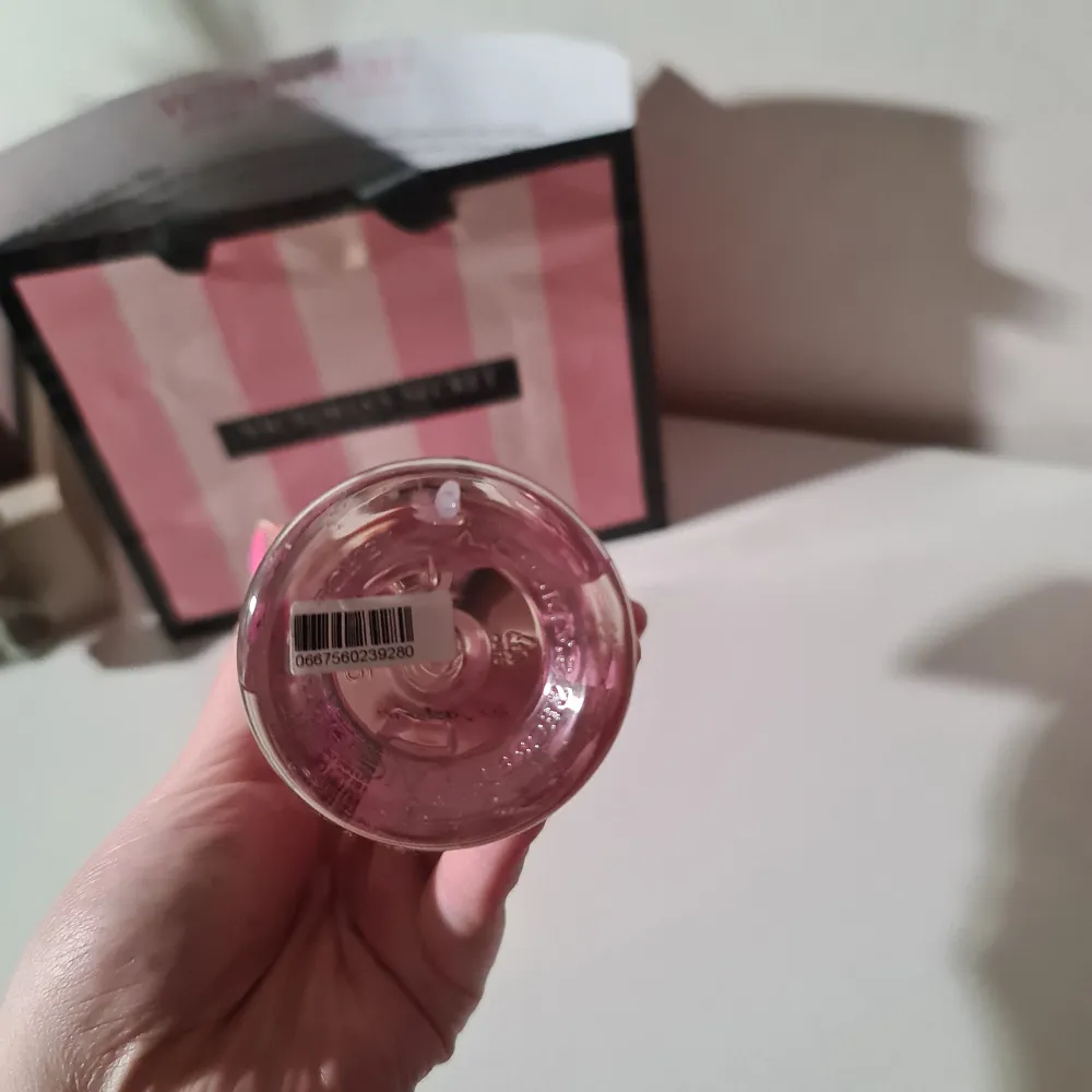 Säljer en Dreamy Petals Fragrance Mist från Victoria's Secret med doft av saftig hallon och te. Flaskan är dekorerad med blommor och bär i rosa och gröna nyanser, och har en elegant guldfärgad kork. Perfekt för att fräscha upp din dag med en blommig och fruktig doft. Helt ny och oanvänd!. Perfume.