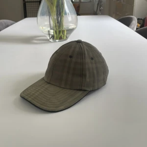 Burberry keps - Använt skick en lite skada märks inte av när man har på sig den.