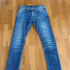 Blå Nudie Jeans - Säljer ett par blå jeans från Nudie i modellen Grim Tim . Färg/tvätt: Ojai Blues. Storlek: 32/32. Jeansen är i väldigt bra skick då jag vuxit ur dem