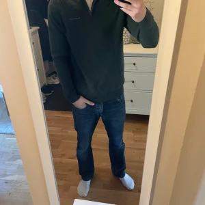 Grön tröja med dragkedja från Bondelid - Säljer en stilren grön tröja från Bondelid med dragkedja vid halsen. Tröjan har långa ärmar och en ribbad krage. Perfekt för en avslappnad och snygg look.