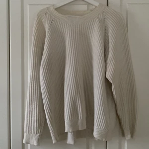 Vit stickad tröja från Filippa K - Säljer en stilren vit stickad tröja från Filippa K. Tröjan har en ribbad struktur och långa ärmar, perfekt för kyligare dagar. Enkel och tidlös design som passar till det mesta. Perfekt för dig som gillar klassisk stil! 🤍