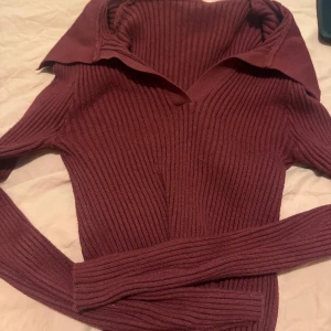 Vinröd stickad tröja - En jätte snygg vinröd stickad tröja från shein som har en öppen krage. Inga defekter.