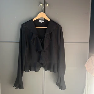 Volangblus  - Svart blus med volanger och en v-ringning💕