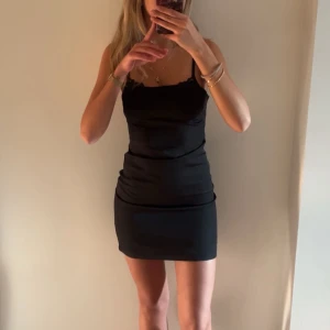 Svart kortklänning - Snygg svart kortklänning utan axelband med figurnära passform. Perfekt för en kväll ute eller en speciell tillställning. Enkel och stilren design som framhäver silhuetten. Obs att jag har en bh, det är en tubklänning. Aldrig kommit till användning endast tvättad🩷🩷