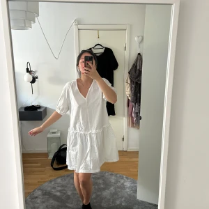 Vit klänning med v-ringning - Säljer en luftig vit klänning med v-ringning och korta ärmar. 