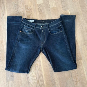 Replay Anbass Hyperflex - Snygga mörkblå jeans från Replay i modellen Anbass Hyperflex. De har en klassisk femficksdesign med kontrastsömmar och en knappgylf. Perfekta för en stilren look. Jeansen är sjukt snygga och nästan helt nya! Hör gärna av er vid frågor eller fler bilder. 