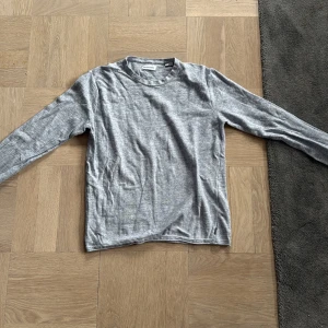 Grå tröja från Jack & Jones - Säljer en stilren grå tröja från Jack & Jones. Tröjan är långärmad och tillverkad i ett mjukt material som passar perfekt för både vardag och avslappnade tillfällen.