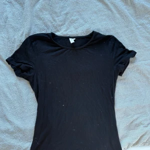 Svart t-shirt från Nelly - Säljer en klassisk svart t-shirt från Nelly. Den har en enkel design med korta ärmar och rund halsringning. Perfekt basplagg för alla tillfällen. 🖤
