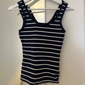 Randig ribbad linnetopp - Snygg randig linnetopp i marinblå och vit, med ribbad struktur. Köpt i en random butik i Australien. Den är i storlek S, och passar mig bra. Den är däremot stretching och passar en storlek upp. Aldrig använd men har tyvärr tagit bort prislappen.🩵
