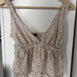 Blommig topp - Söt blommig blus med volangdetaljer och v-ringning. 