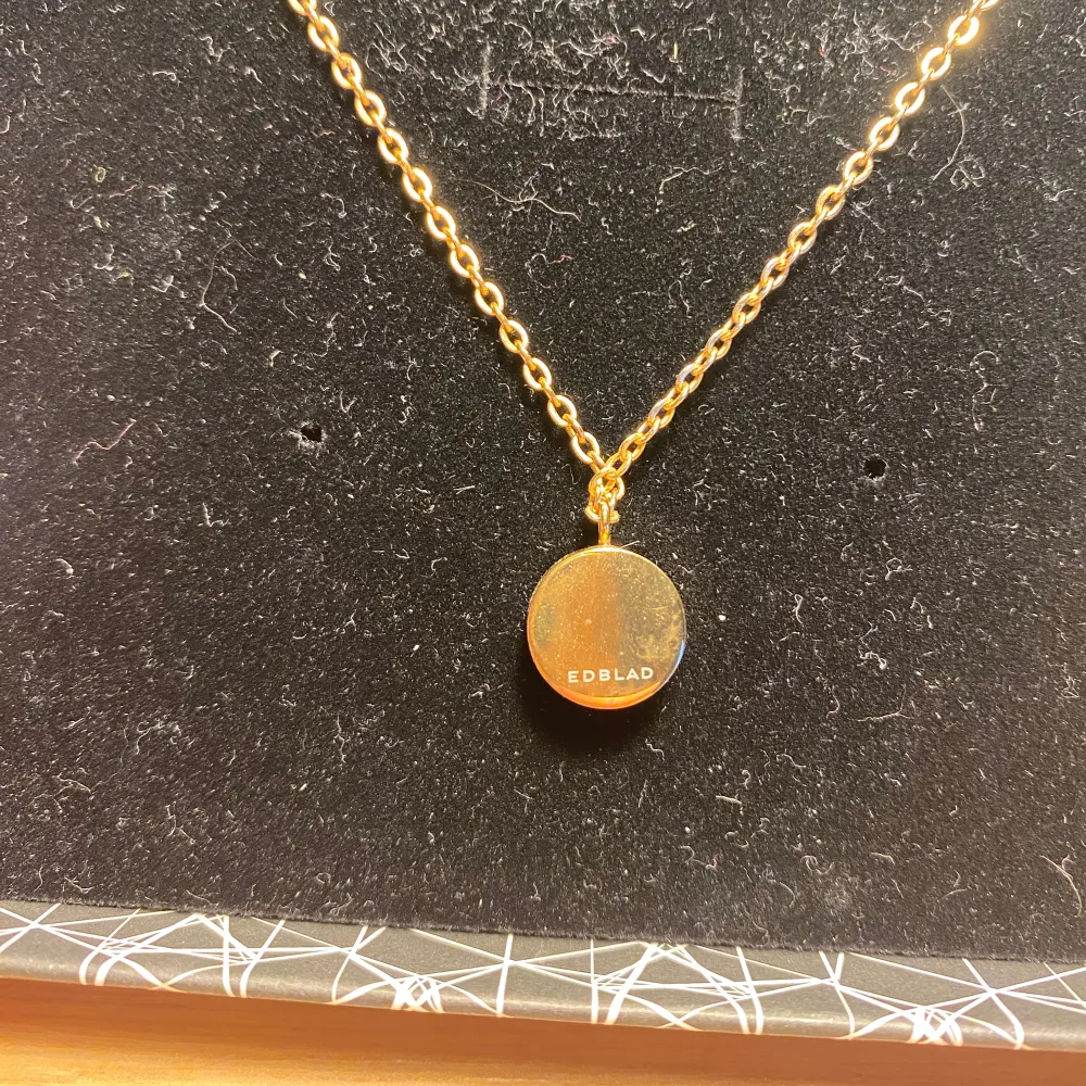 Elegant guldhalsband från Edblad med ett runt hängsmycke prytt med glittrande stenar. Är en äldre kollektion så har stämpeln bak på berlocken. Använd men inga tydliga defekter. Box medföljer!💕. Asusteet.