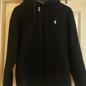 Svart hoodie från Ralph Lauren - Säljer en svart hoodie från Ralph Lauren med dragkedja. Väldigt fint skick