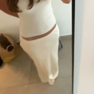 Vit satin långkjol - Säljer en elegant vit långkjol💞Kjolen har en stilren design och är perfekt för sommarens festligheter. 