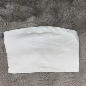Vit bandeau tubtopp från 157 - Enkel och stilren vit bandeau tubtopp från 157 i stretchig bomull. Perfekt att styla under skjortor eller till höga jeans. Mjuk och bekväm passform utan axelband, passar dig som gillar minimalistiska plagg.
