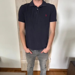 Mörkblå pikétröja från Ralph Lauren - Snygg mörkblå pikétröja från Ralph Lauren. Storleken är M och skicket ä bra