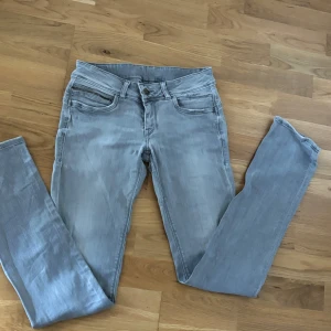 Pepe jeans Lågmidjade W29L34 - Säljer ett par ljusgråa Lågmidjade jeans från Pepe jeans klassiska fem fickor och snygga detaljer på bakfickorna. Jeansen har dragkedjegylf och är tillverkade i mjukt denimtyg som sitter skönt. Långa! Passar mig som är 182 cm lång i längden.
