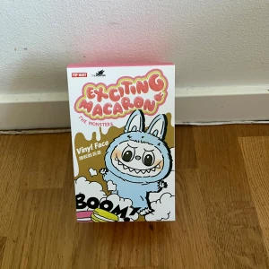 Exciting Macaron: The Monsters - En färgglad och lekfull docka med tecknade monster i olika smaker och stilar. Perfekt för dig som gillar söta och roliga illustrationer med en twist! Upptäck olika karaktärer och samla dina favoriter. Passar alla åldrar 