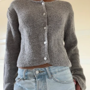 Grå ribbstickad kofta med knappar - Supermysig grå ribbstickad kofta med rund hals och vita knappar framtill. Super skick, knappt använd 💞Från koreanska Lewkin!