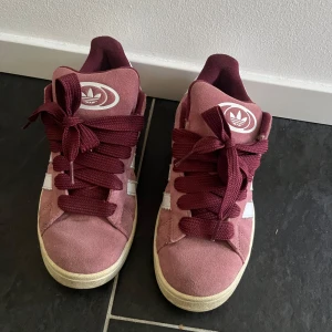 Adidas Campus vinröda sneakers - Säljer nu dessa snygga Adidas Campus sneakers i vinröd med vita detaljer. Skorna har breda vinröda snören, vit logga på plösen och hälen. Perfekta för dig som behöver höst skor nu!