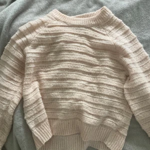 Ljusbeige stickad tröja Samsa M - Supermysig ljusbeige stickad tröja från Samsa i storlek M. Tröjan har ett randigt strukturmönster, ribbade muddar och lång ärm. Perfekt för lager-på-lager och chill dagar. Snygg till både jeans och kjol!