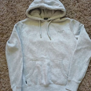 Grå superdry hoodie - Säljer en grå superdry hoodie i storlek S/M. Säljer pga att den va för stor. Det är ba komma om vid frågor
