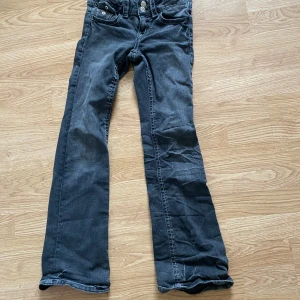 Svarta low waist bootcut jeans - Jag säljer ett par svarta low waist bootcut jeans från Gina. De är uppsprättade. Ett hål i bakfickan och det går inte igenom hela byxan bara i fickan. Man ser på bilden hur de ser ut där nere