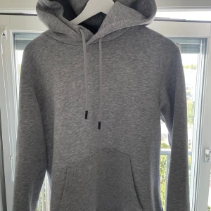 Går hoodie  - Säljer en grå hoodie från Jack & Jones. Hoodien är i nyskick och har storleken S. Vid fler frågor och funderingar är de bara att höra av sig