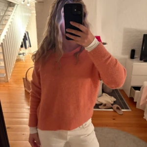 Korallfärgad stickad tröja Samsøe Samsøe - Mysig stickad tröja från Samsøe Samsøe i en korall/rosa färg. Rund halsringning och långa ärmar med ribbade muddar. Nypris 1200