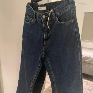 Perfect Jeans mörkblå raka jeans - Mörkblå jeans från Gina tricot, aldrig använt. Hög midja och knappstängning framtill. Jeansen har en enkel och clean look som funkar till många olika stilar. Materialet är slitstark denim i bomull.
