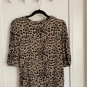 Leopardmönstrad tröja med puffärm - Snygg tröja med leopardmönster i beige och svart. Modellen har puffade axlar och trekvartsärmar som ger en cool siluett.Materialet känns mjukt och följsamt mot huden.