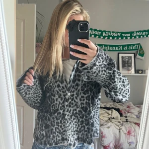 Leopardmönstrad teddyjacka i grått - Säljer en fluffig teddyjacka med leopardmönster i grå och svart. Jackan har knappar framtill, krage och två bröstfickor. Modellen är loose fit och har långa ärmar. säljer för den inte kommer till användning❤️