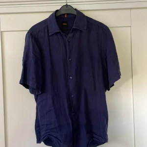  BOSS kortärmad linneskjorta  - Snygg mörkblå kortärmad skjorta från BOSS i regular fit, storlek S, använd fåtal gånger.