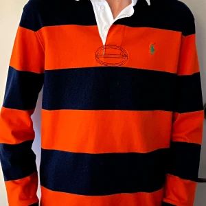 Ralph Lauren långärmad piké  - Snygg Blå/Orange långärmad Piké. Har haft på den typ 3 gånger totalt. Samma som Kanye west anväde när han släppte Graduation