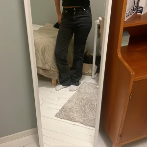 Svarta bootcut jeans - Snygga svarta jeans med bootcut passform och klassisk femficksdesign. Jeansen har en något högre midja och raka ben som blir vidare nedtill. Nästan helt säkert att de är från HM. 